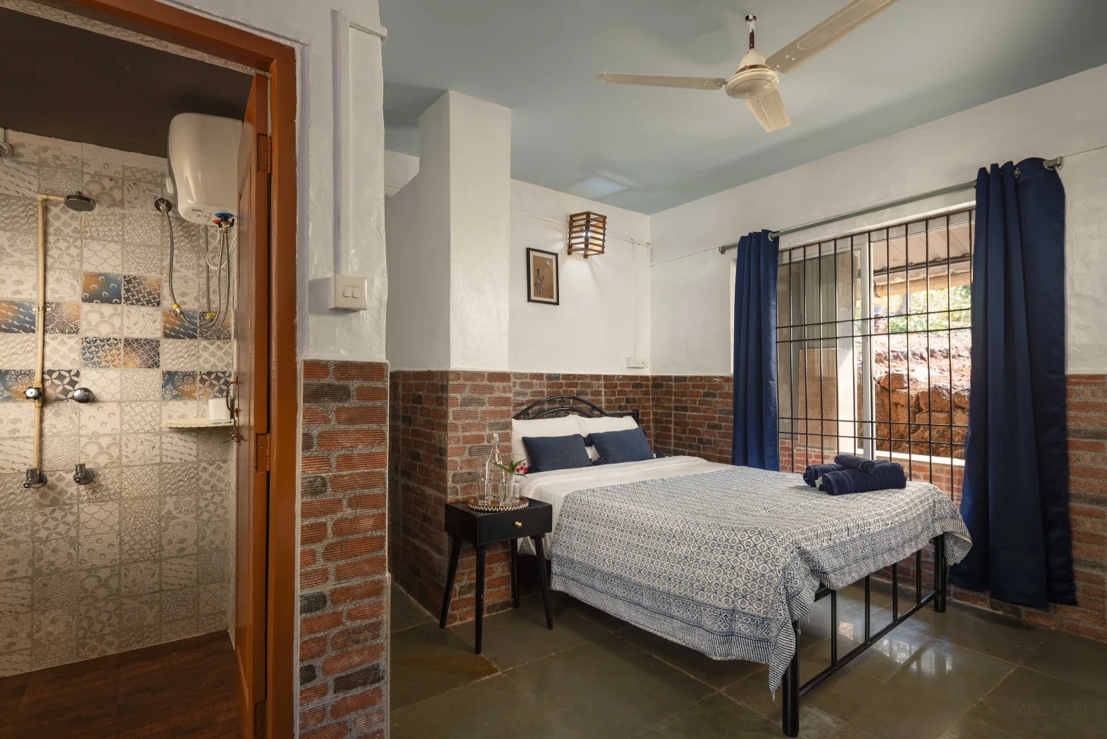 A guest bedroom with a double bed, block-print bedding and en-suite shower at The Haven Goa
